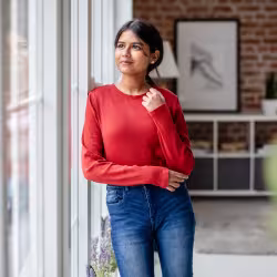 Ung kvinna lutar mot vägg