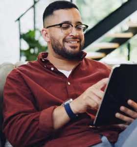 Man läser på ipad i soffa