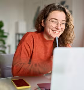 Glad kvinna framför dator